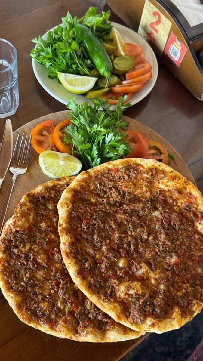 Masada salata ve turşuyla servis edilen lahmacun