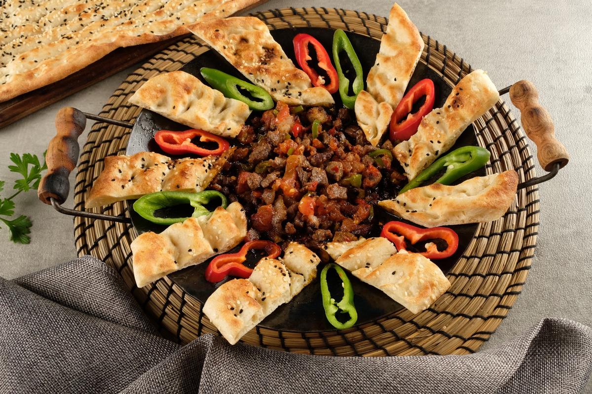 Kavurma, pide dilimleri ve biberle servis